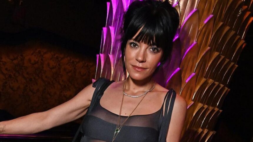 Η Lily Allen ποζάρει κρατώντας το άλμπουμ “West End Girl”, χαμογελώντας μετά την επιτυχία του