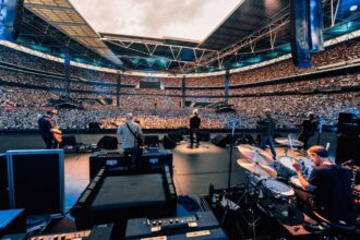Οι Oasis στη σκηνή του Wembley Stadium κατά τη διάρκεια της περιοδείας Live 25