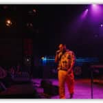 Pan Pan περπατά τη νύχτα σε φωτισμένο δρόμο της Αθήνας με ακουστικά