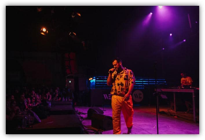 Pan Pan περπατά τη νύχτα σε φωτισμένο δρόμο της Αθήνας με ακουστικά