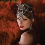 Η Taylor Swift ποζάρει στο κόκκινο χαλί, ενώ δίπλα προβάλλεται εικόνα από το βίντεο του George Michael