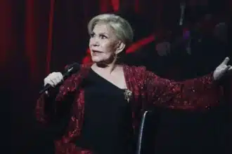 Μαρινέλλα σε εμβληματική εμφάνιση με φόντο σκηνή και φώτα, αναφορά στη διαχρονική καριέρα της