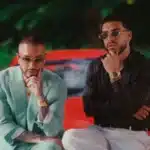 J Balvin και Ryan Castro σε σκηνή από το βίντεο του “Pal Agua” με καλοκαιρινό φόντο και latin αισθητική